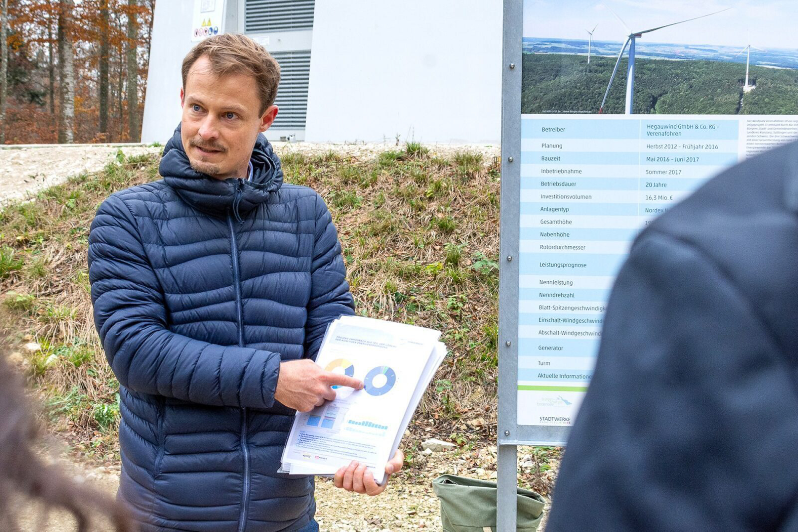 Dieses Bild zeigt einen Projektleiter, der einer Gruppe von Personen eine Grafik erklärt. Es steht für den Windpark Chroobach.