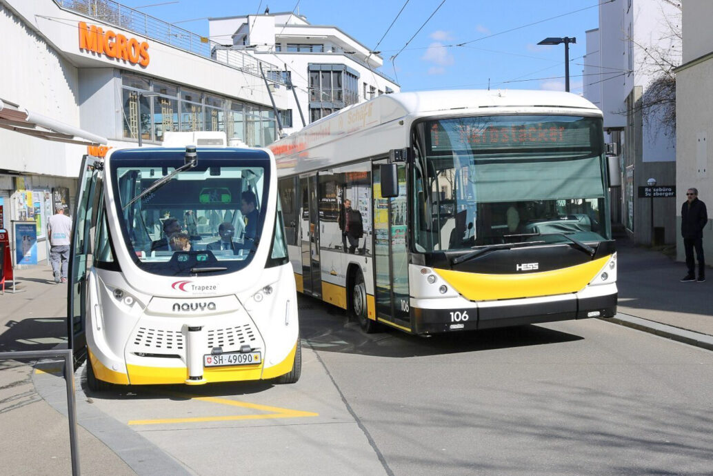 Dieses Bild zeigt einen selbstfahrenden Bus neben einem manuell gesteuerten Bus. Es steht symbolisch für den Fortschritt im Kanton Schaffhausen.